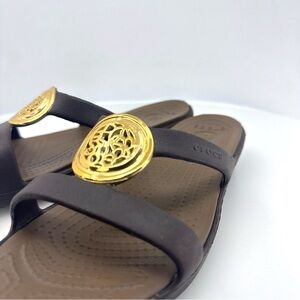 CROCS Dark Brown Slide Sandals with Gold Medallion